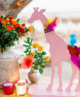 colourful baptism decor in greece with pink giraffes and feathers